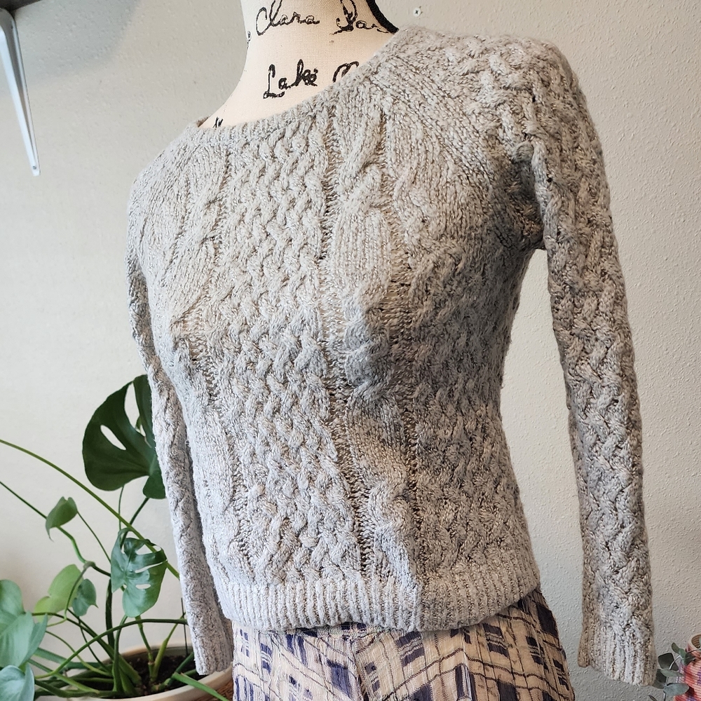 Grey cable knit sweater with waffle knit sleeves and back.